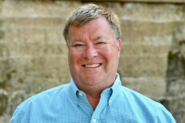 A man with short hair and a blue shirt.